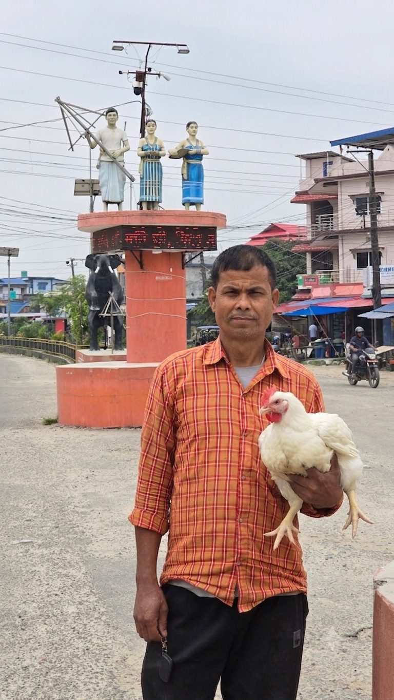 Farmer at Basnet Krishi Farm holding a chicken